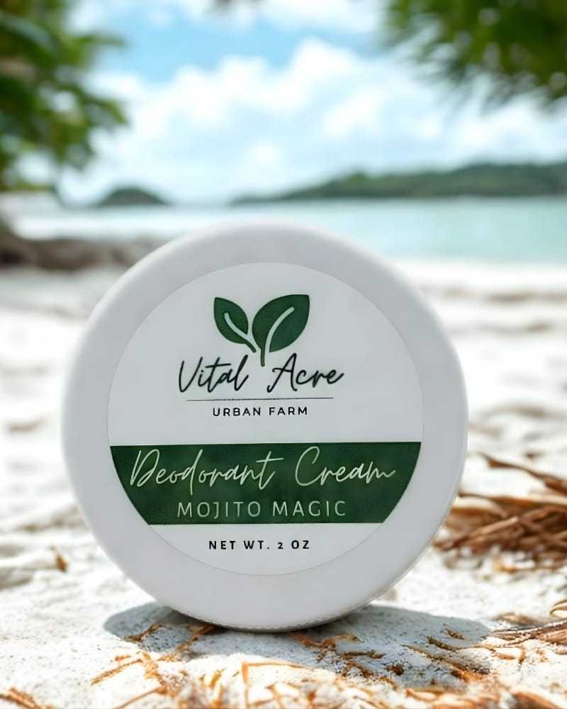Deodorant cream jar labeled "Mojito Magic" on sandy beach with ocean in background.
