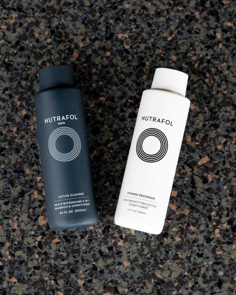 Nutraceutical hair care products on a speckled surface.