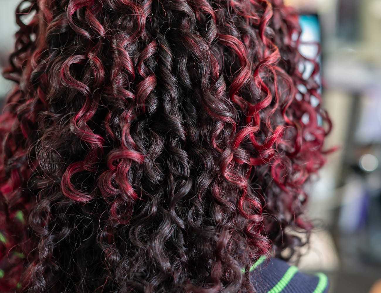 Curly hair with vibrant red highlights.
