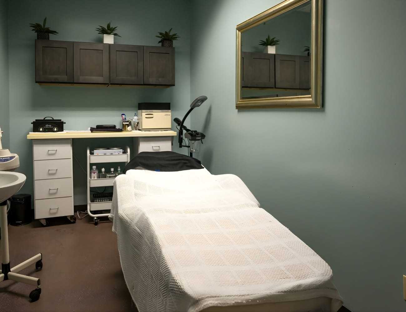 Spa treatment room with a massage table, cabinets, and calming decor.